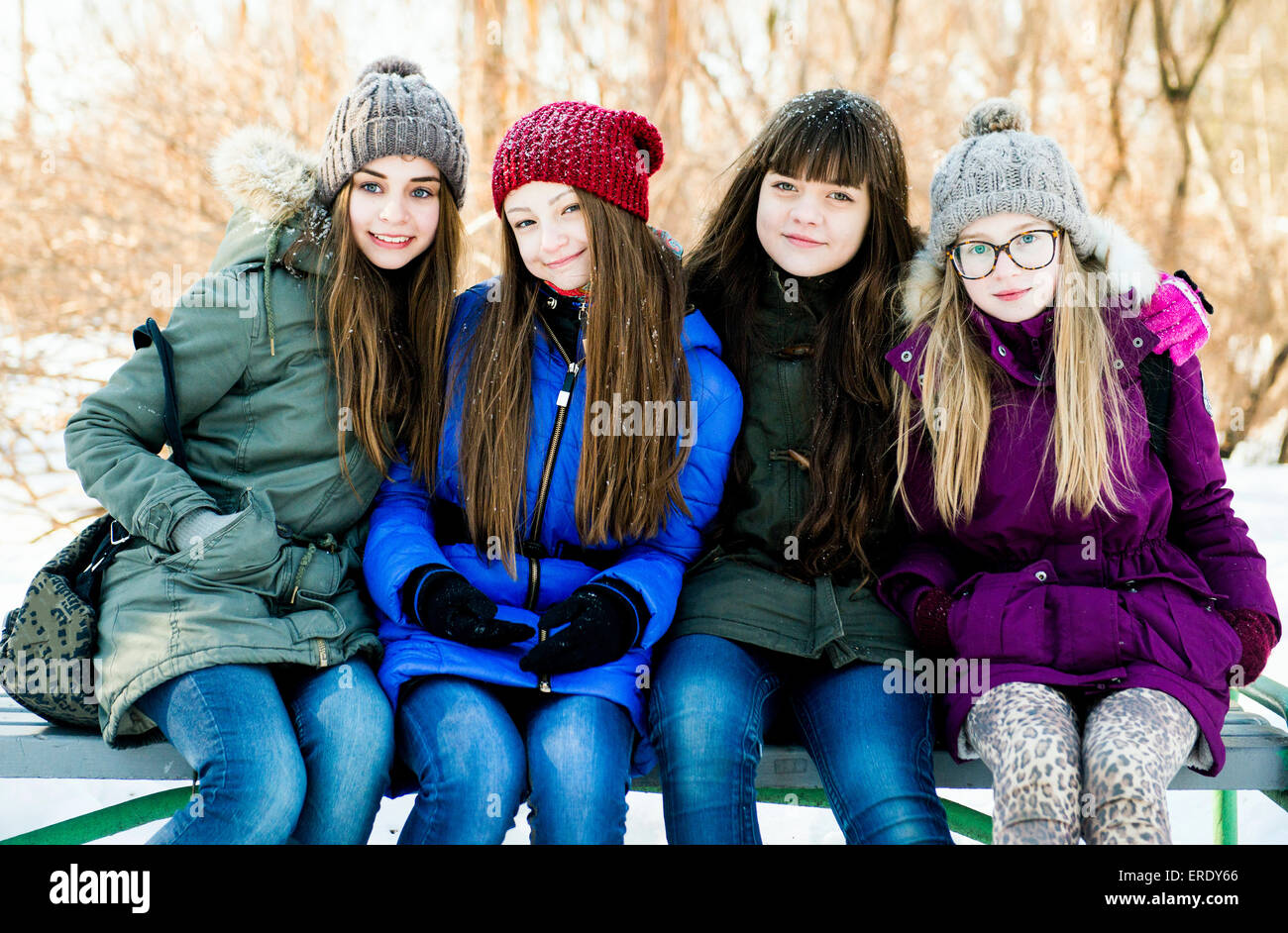 Caucasian girls smiling sur banc en hiver Banque D'Images
