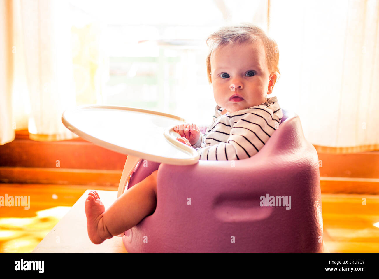 Caucasian baby girl sitting in chaise haute Banque D'Images