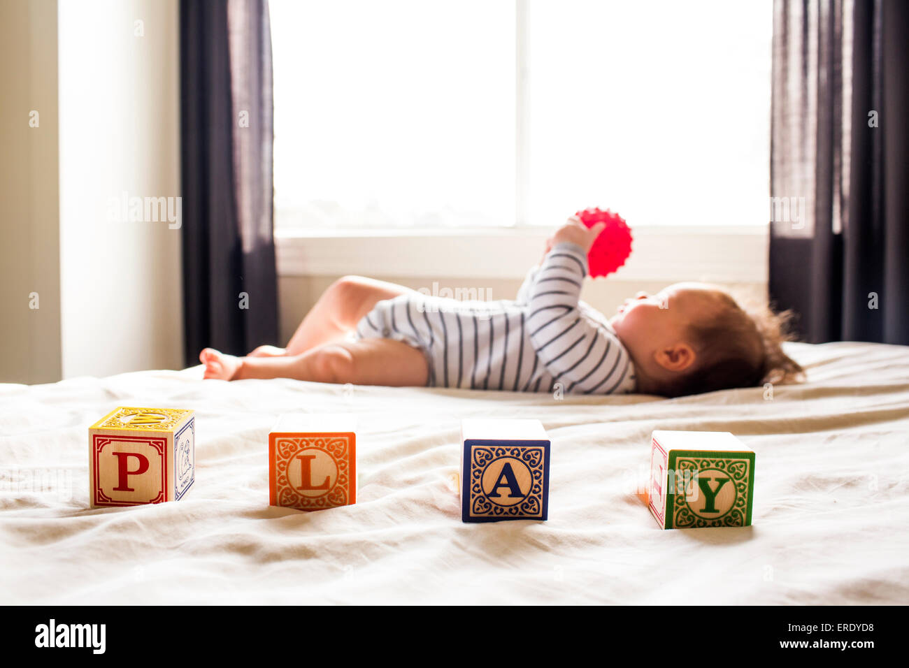 Caucasian baby girl playing on bed Banque D'Images