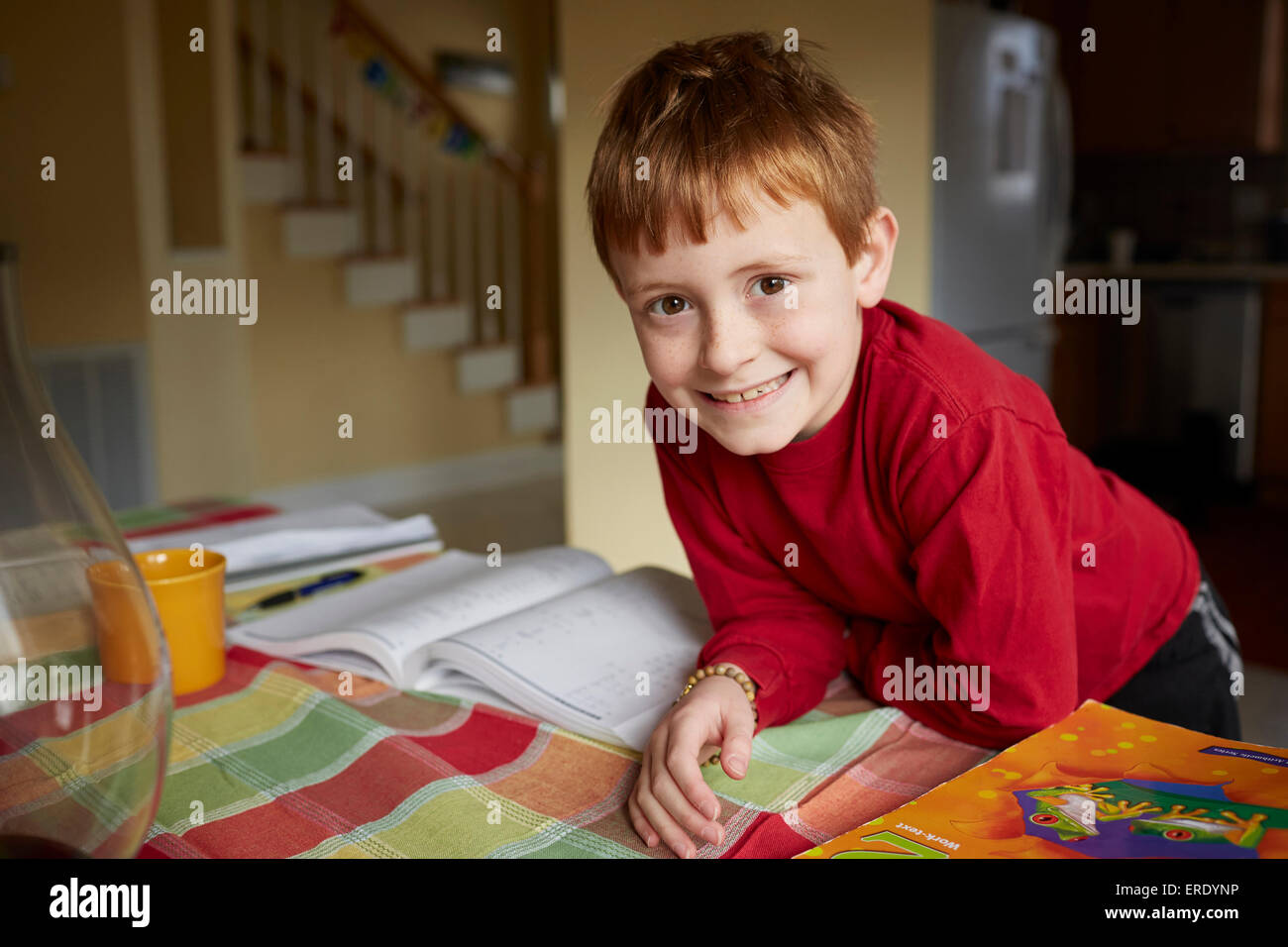 Caucasian boy doing homework at table Banque D'Images