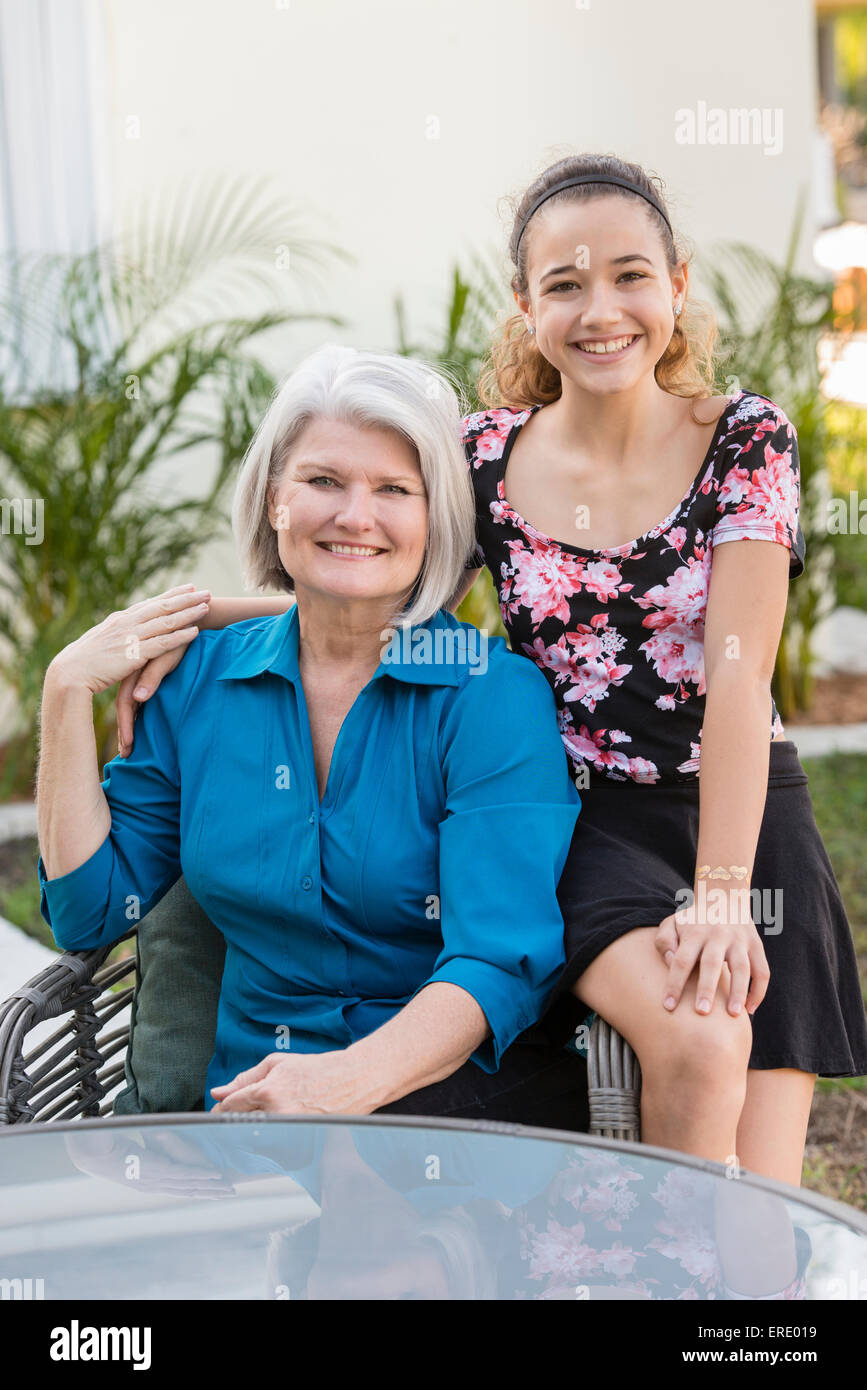 Plus grand-mère et petite-fille smiling in backyard Banque D'Images