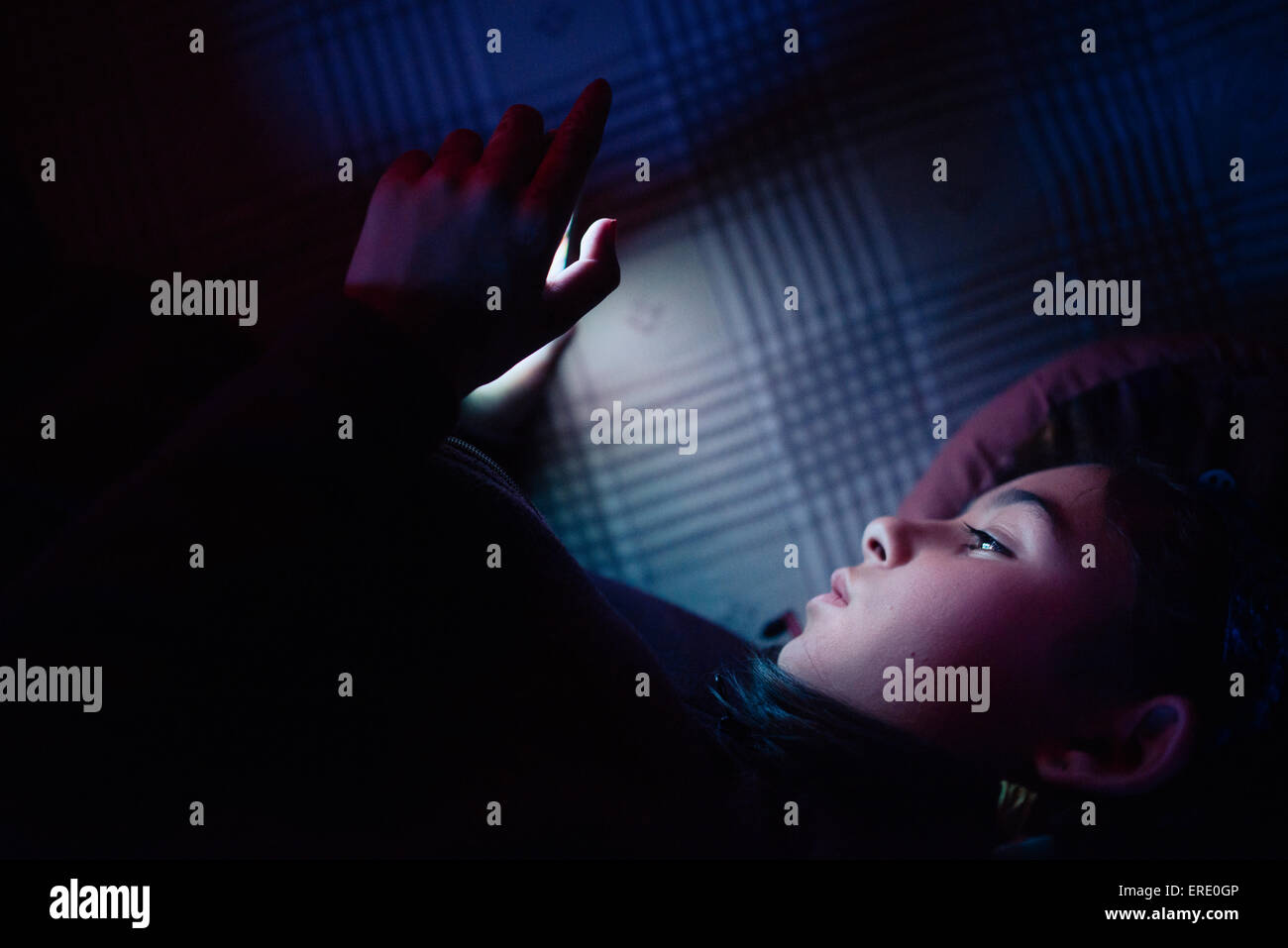 Mixed Race girl using cell phone at night Banque D'Images