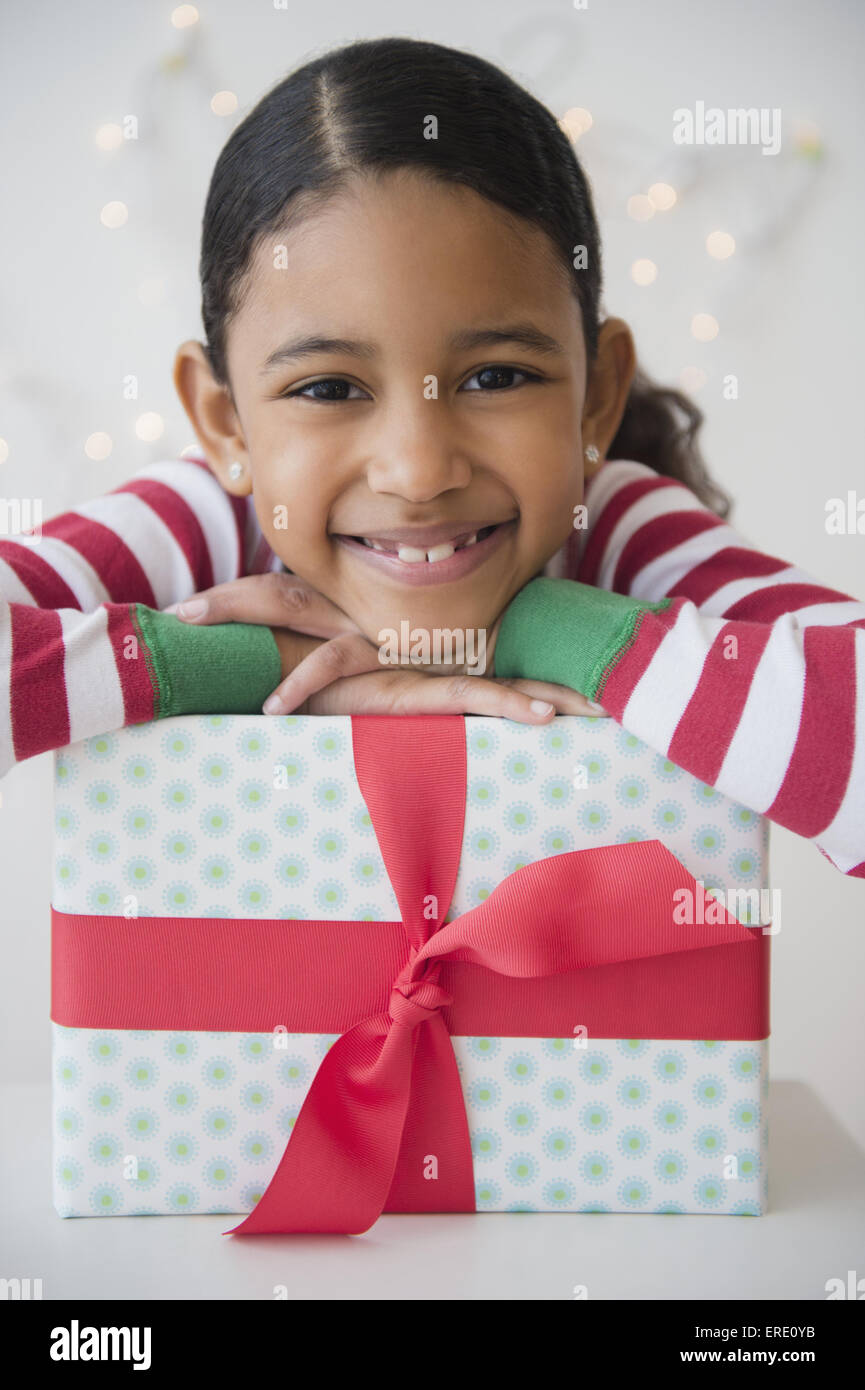Mixed Race girl smiling with wrapped gift Banque D'Images