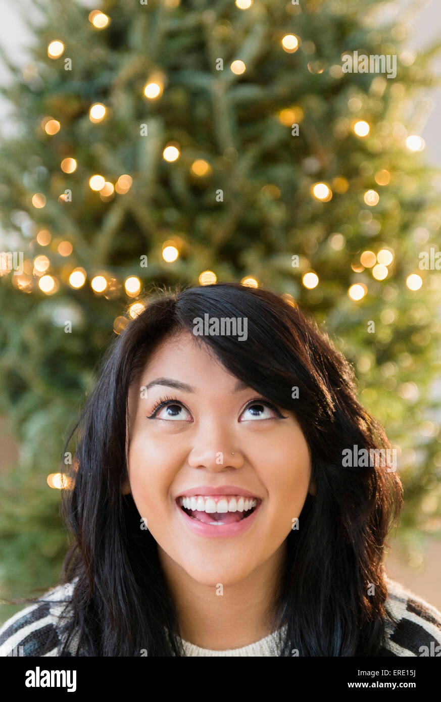 Pacific Islander woman looking up near Christmas Tree Banque D'Images