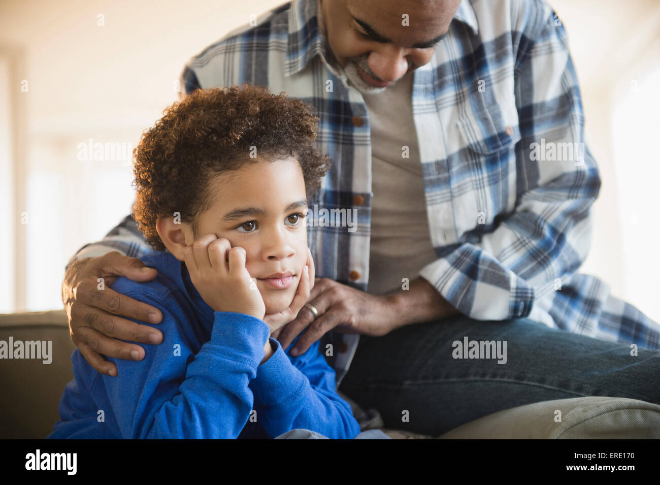 Mixed Race grand-père petit-fils réconfortante sur canapé Banque D'Images