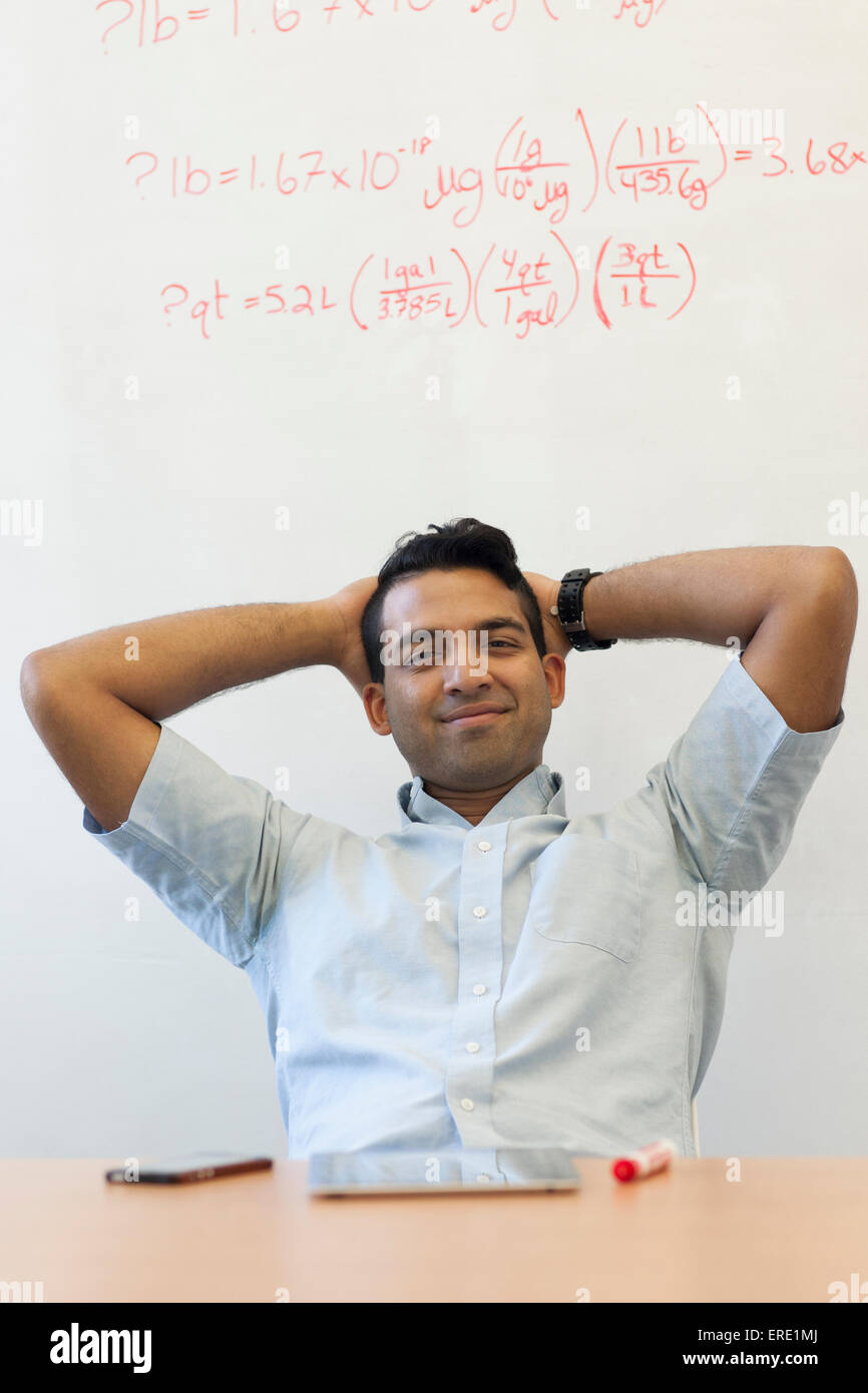 Asian businessman relaxing at desk Banque D'Images