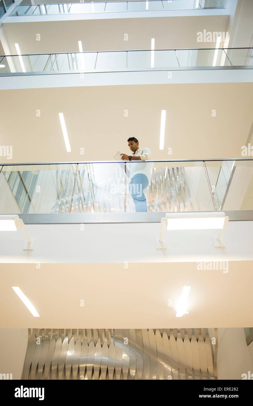 Asian businessman standing sur balcon de l'immeuble de bureaux Banque D'Images
