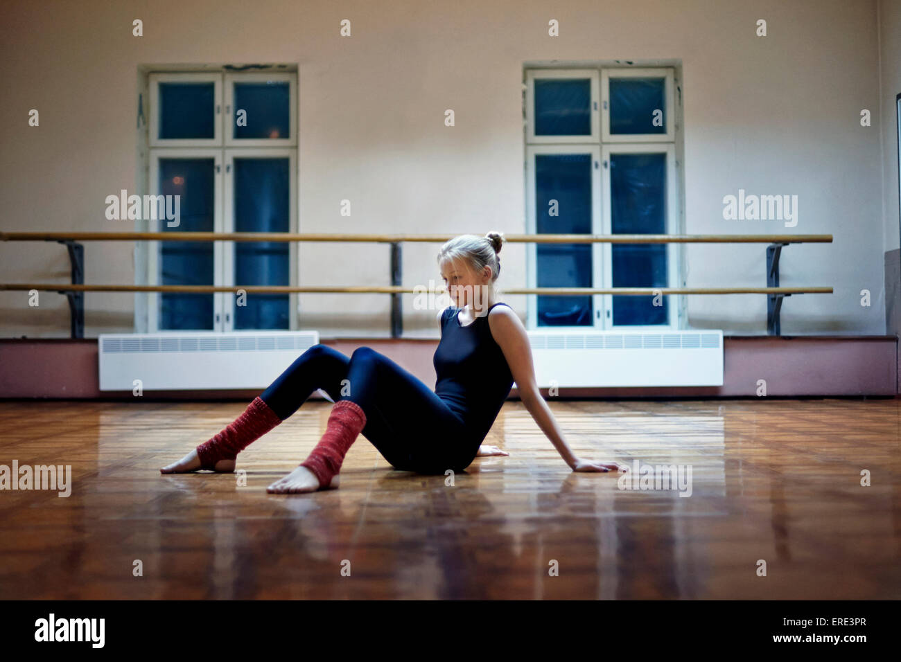 Caucasian dancer assis sur studio-de-chaussée Banque D'Images