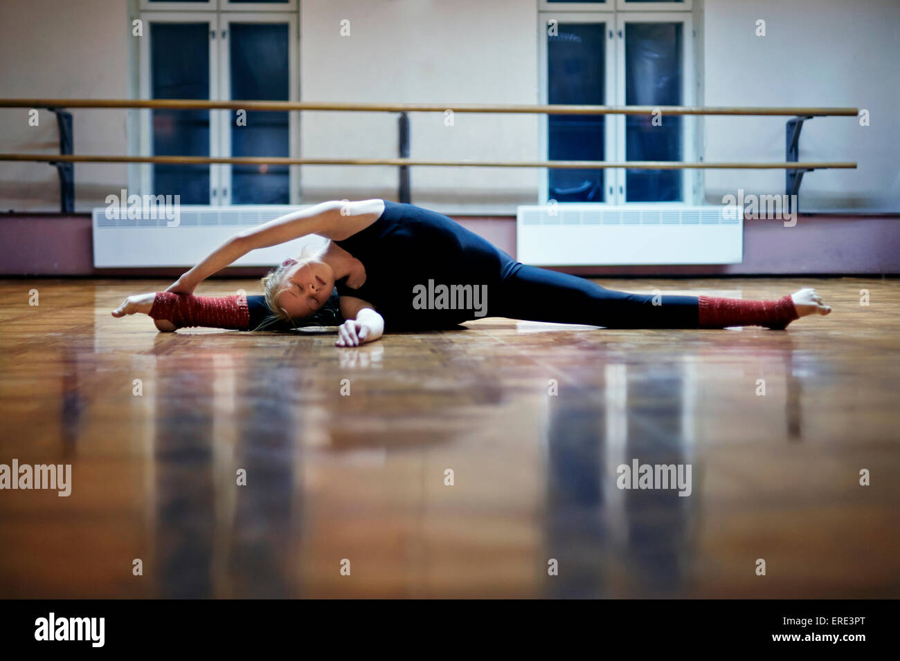 Caucasian dancer stretching faisant se divise sur studio-de-chaussée Banque D'Images