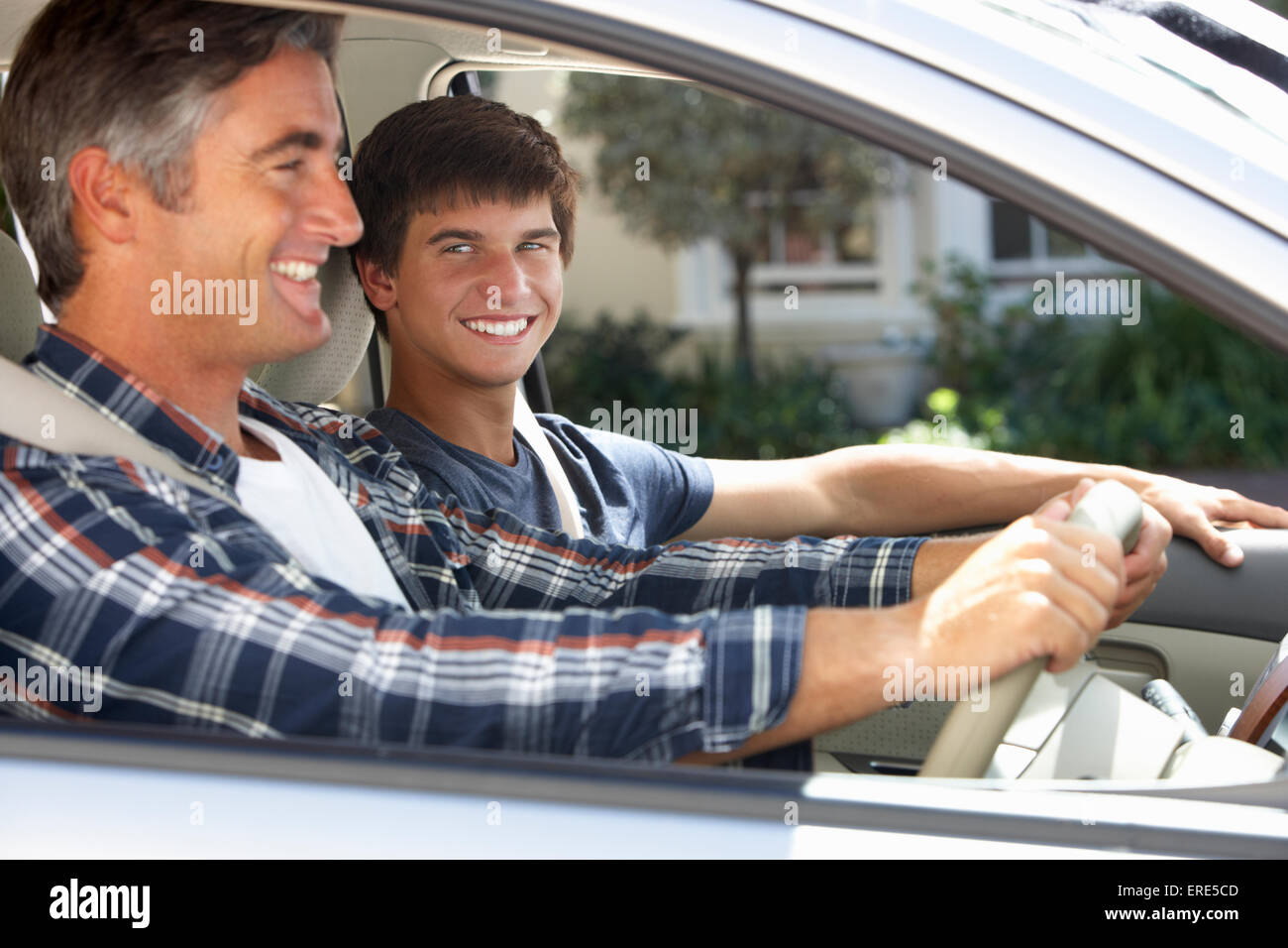 Père sur voiture avec fils adolescent Banque D'Images