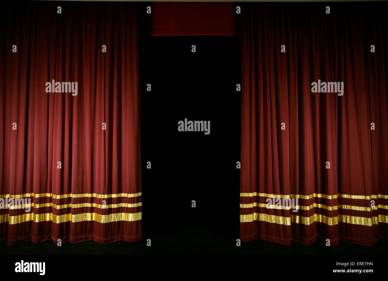Rideaux de scène rouge avec des rayures d'or, partiellement ouvert Banque D'Images