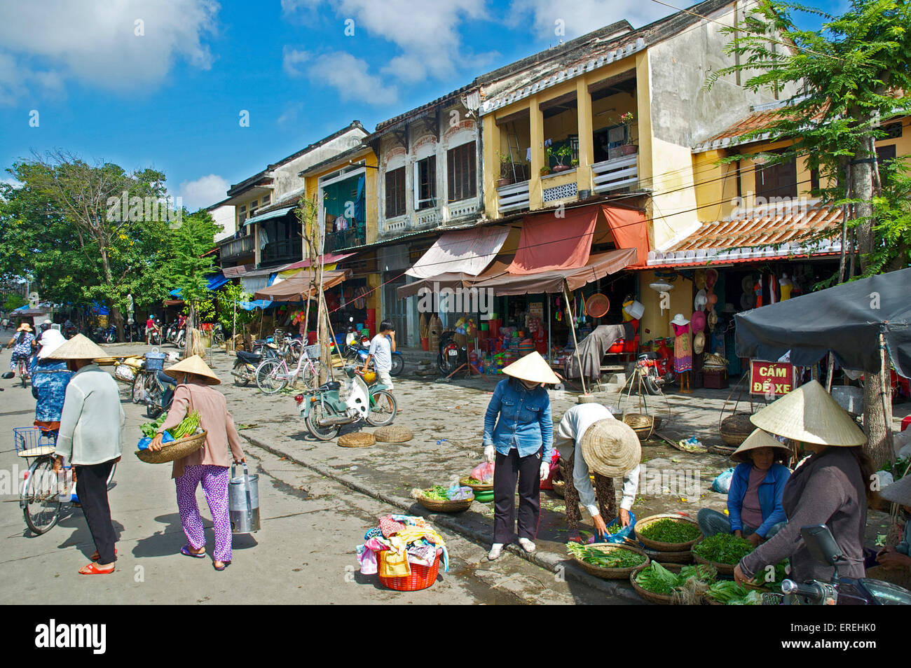 Les vendeurs de rue en face de magasins, Hoi An, Vietnam. Banque D'Images