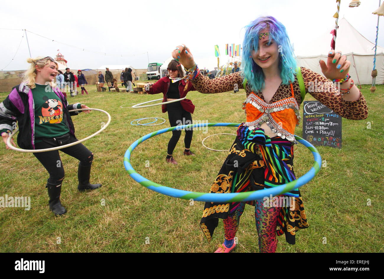 Les jeunes femmes jouent avec des cerceaux dans un champ à l'Y PAS Pikehall, Festival, Derbyshire, UK - été 2014 Banque D'Images