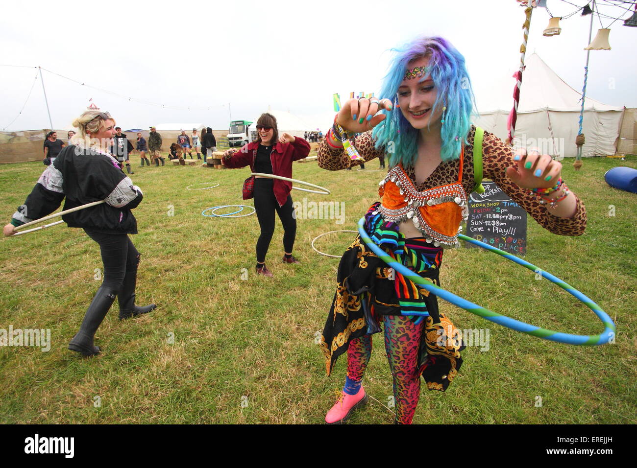 Les jeunes femmes jouent avec des cerceaux dans un champ à l'Y PAS Pikehall, Festival, Derbyshire, UK - été 2014 Banque D'Images
