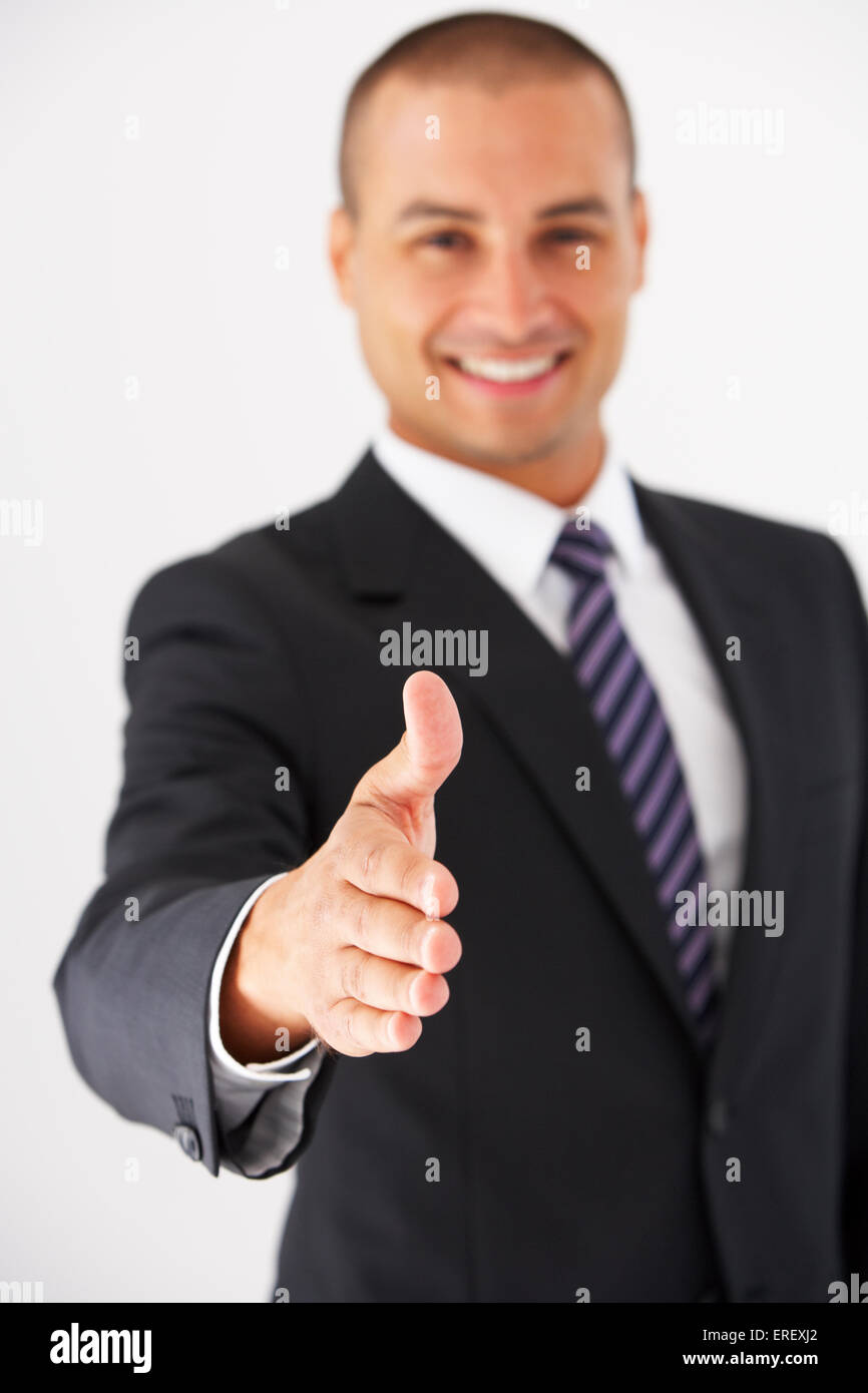 Studio Portrait Of Businessman Reaching Out pour serrer la main Banque D'Images