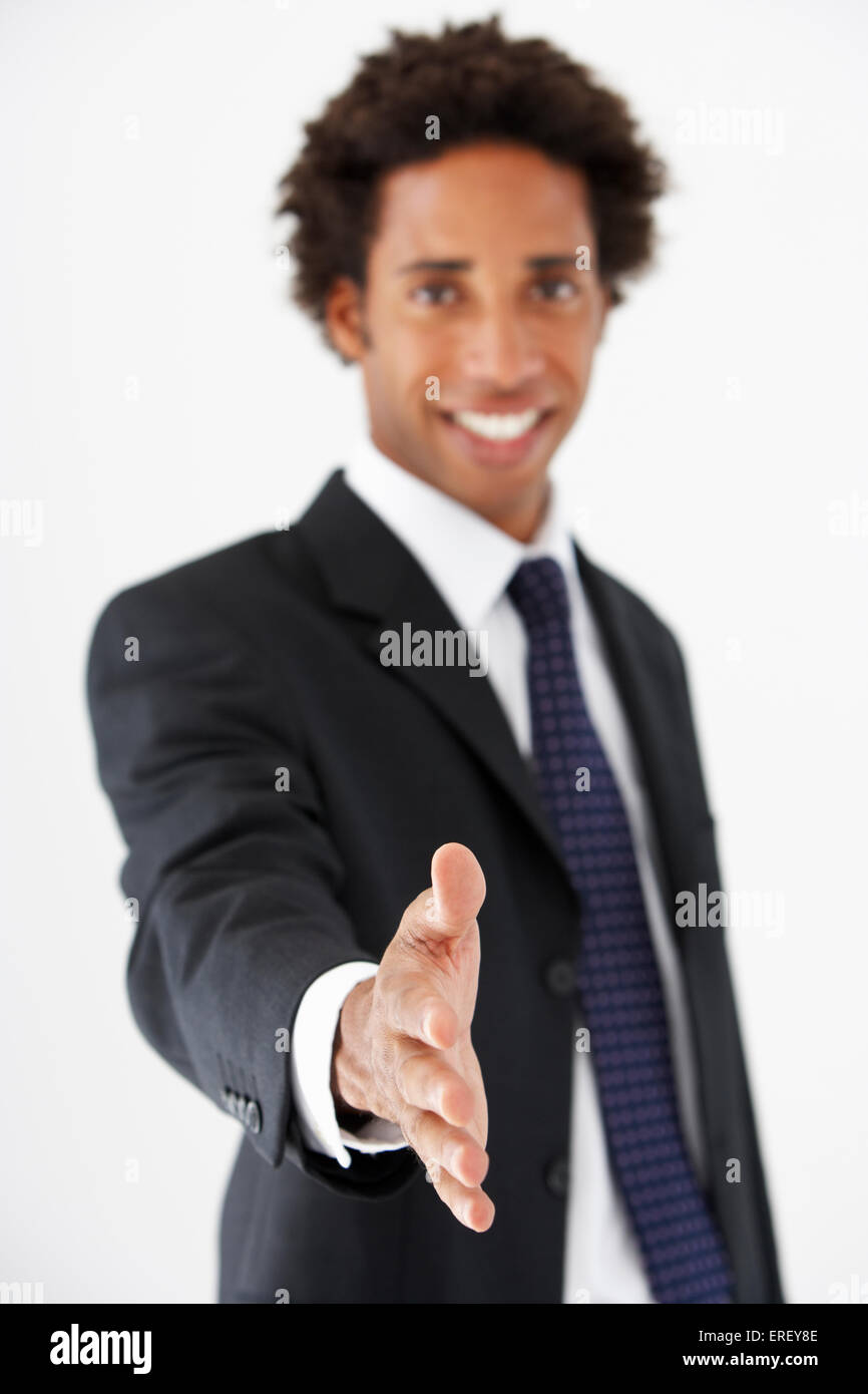 Studio Portrait Of Businessman Reaching Out pour serrer la main Banque D'Images