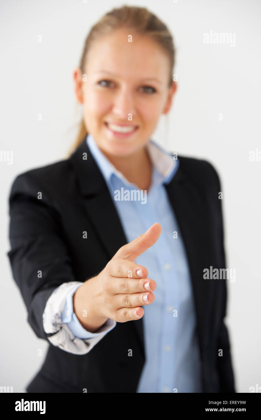 Studio Portrait Of Businesswoman Reaching Out pour serrer la main Banque D'Images
