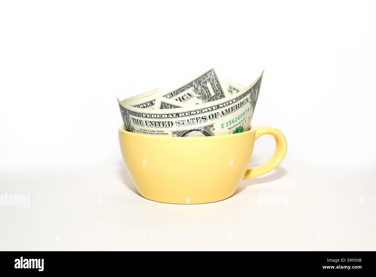 $1 billets américains à une tasse jaune sur fond blanc Banque D'Images