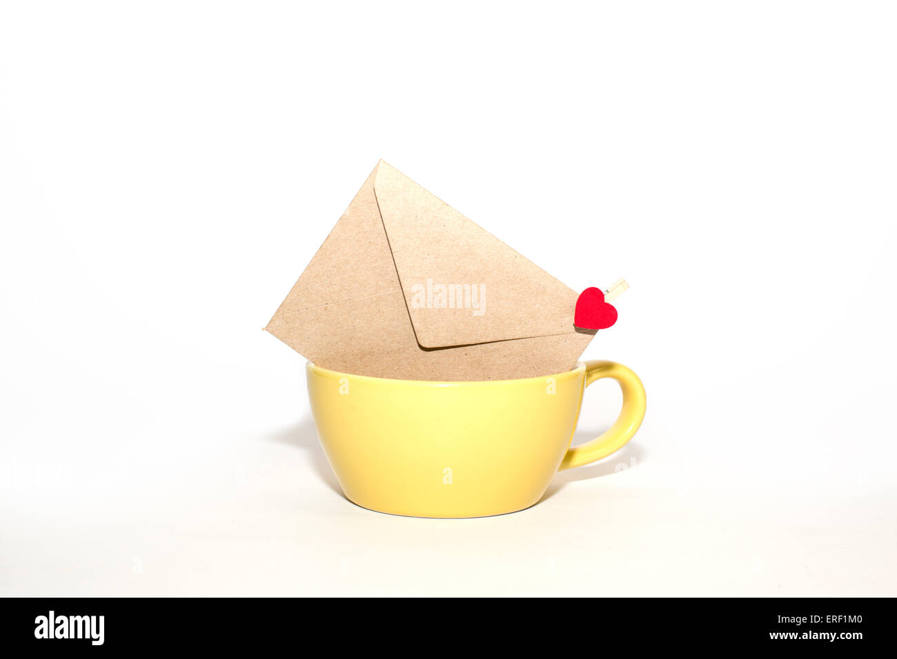 Enveloppe postale avec coeur à la tasse jaune sur un fond blanc. Banque D'Images