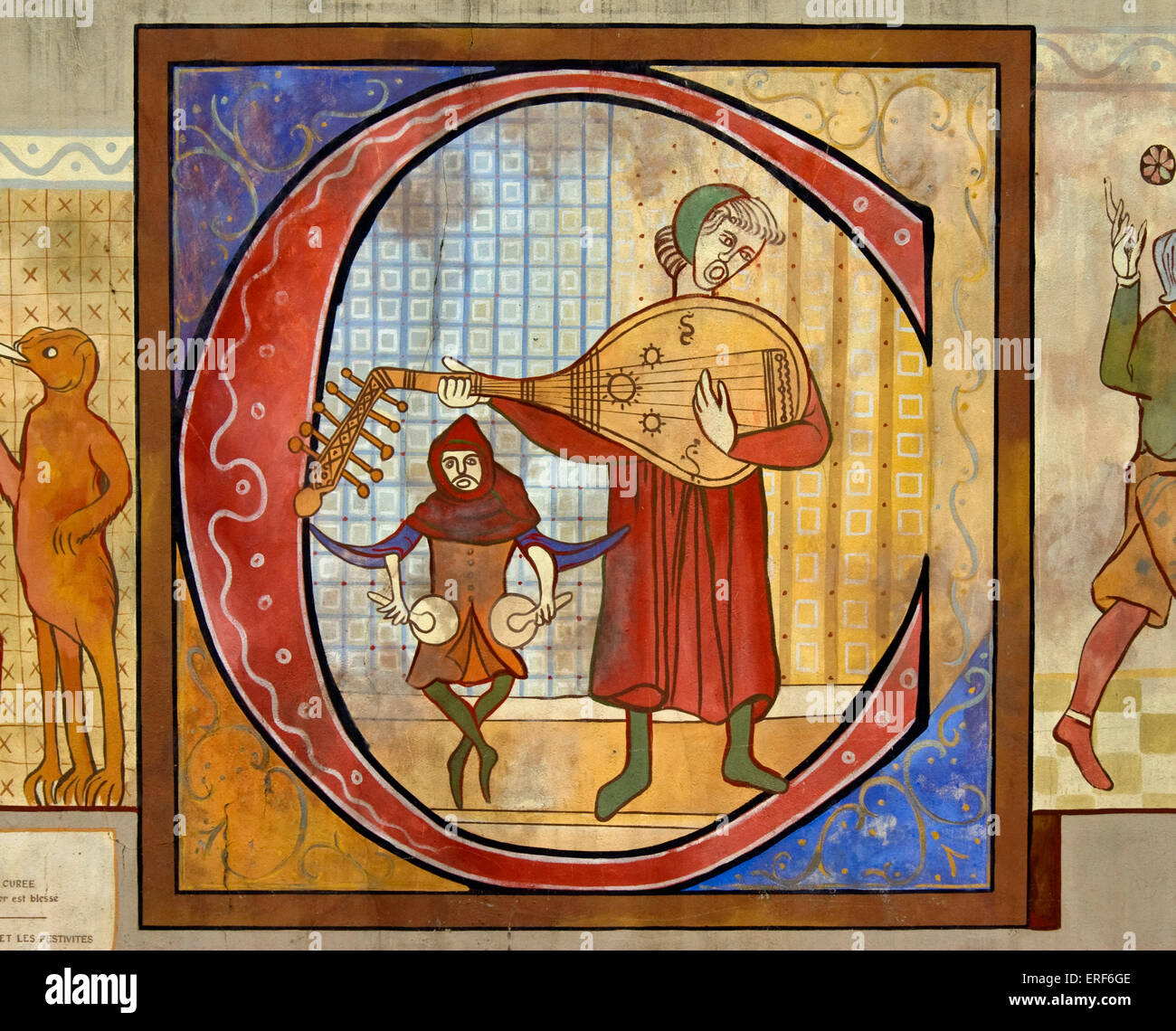Reproduction d'un dessin montrant un joueur de luth médiéval et d'un batteur jouant nakers (ou nakirs). Lettre capitale illuminée Banque D'Images