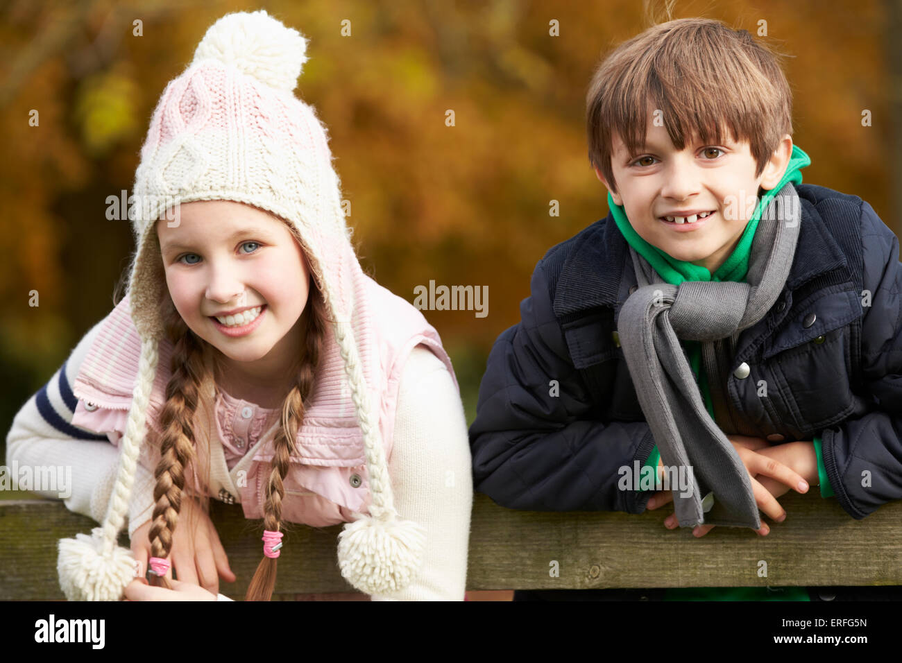 Portrait de deux enfants penché au-dessus de clôture en bois Banque D'Images