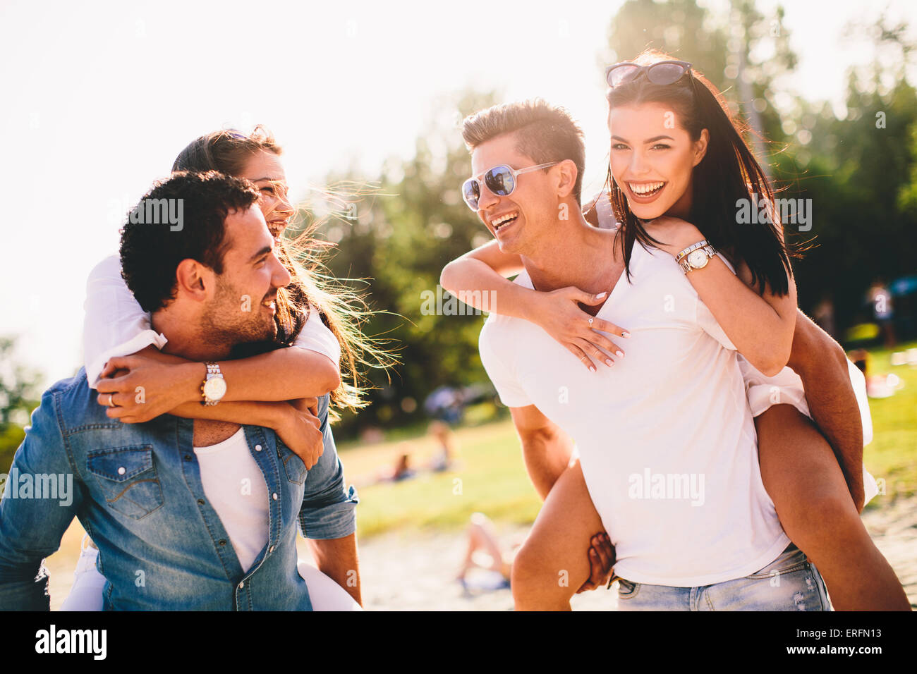 Les jeunes couples s'amusant sur la plage Banque D'Images