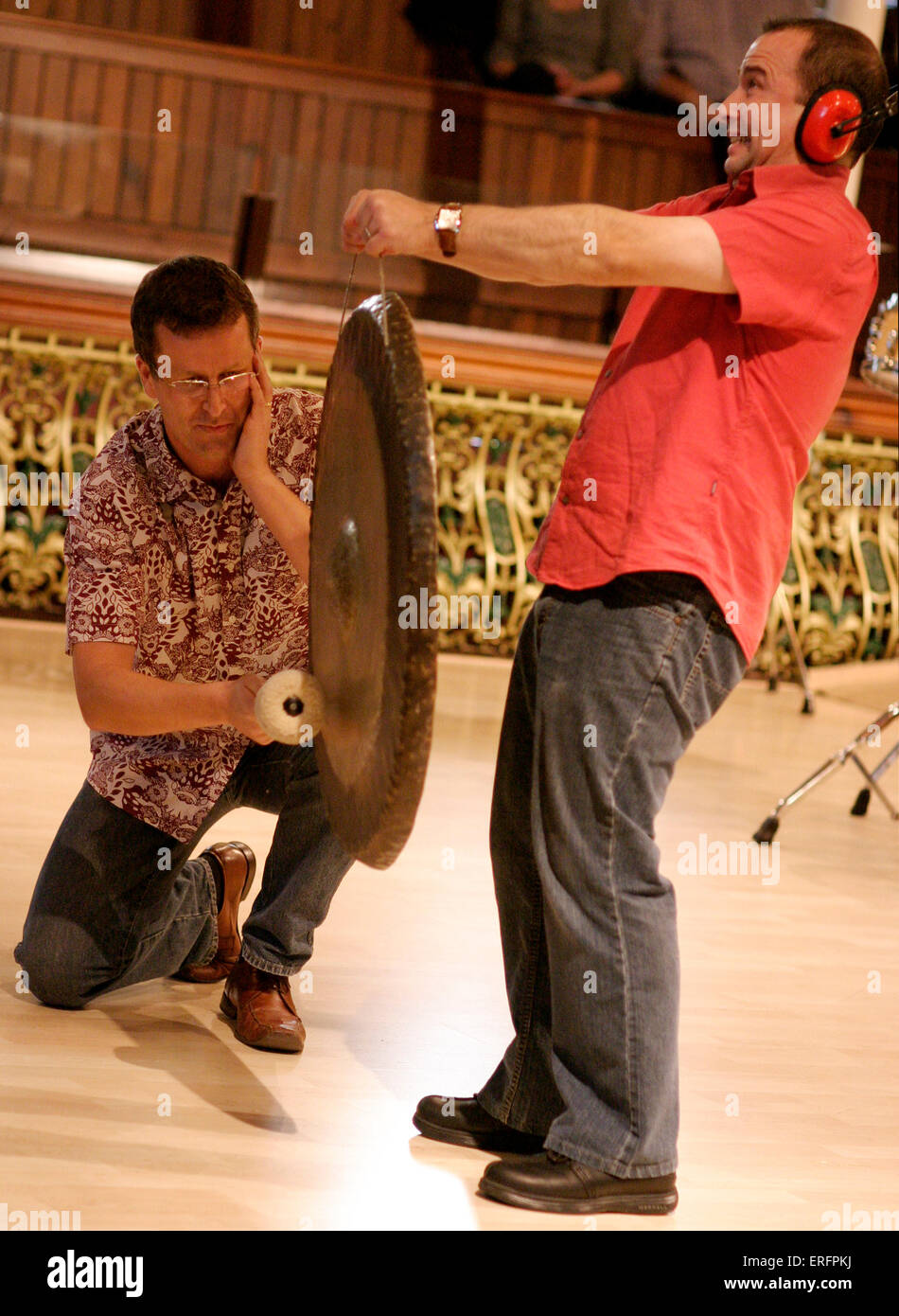 Deux percussionnistes jouant le Tam Tam - dans le cadre d'un atelier de musique. Porter un protège-oreilles. Banque D'Images