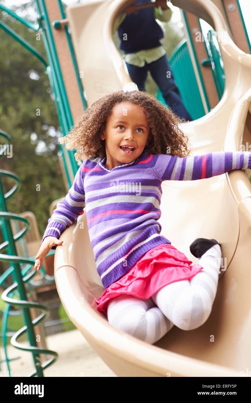 Young Girl Playing On Slide In Playground Photo Stock - Alamy