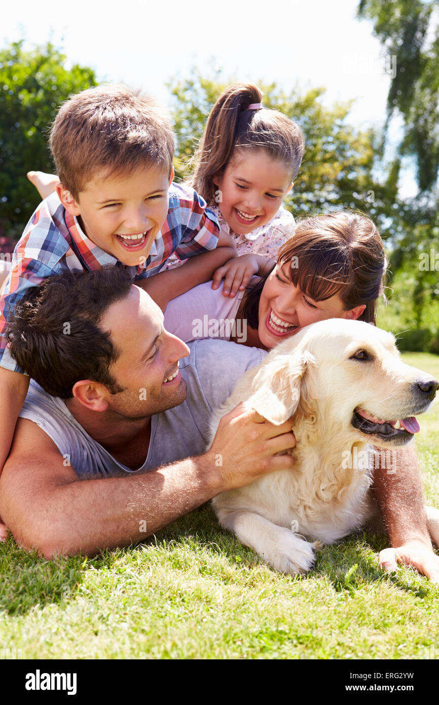 Family Relaxing In Garden With Pet Dog Banque D'Images