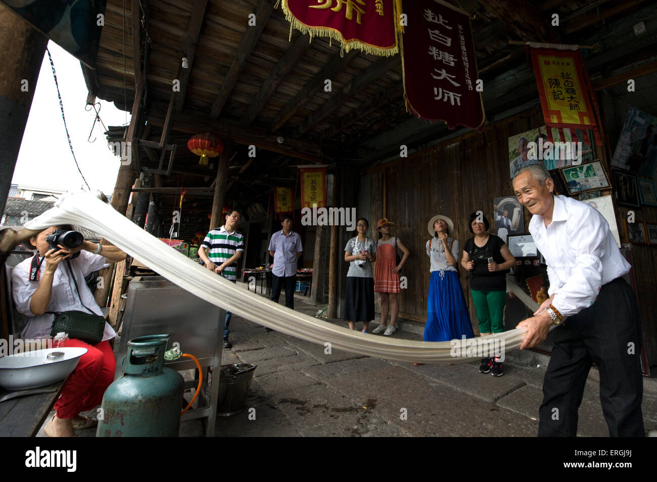 (150603) -- BEIJING, 3 juin 2015 (Xinhua) -- Chen Jinshui, héritier de la technique de l'extraction du sucre collante, demeure d'ondes longues de sucre collant à Anchang Canton de Shanghai, ville de la Chine de l'est la province du Zhejiang, le 2 juin 2015. Chen Jinshui, qui est de plus de 80 ans et a appris la technique de traction de sucre à partir de 13 ans, est toujours un moment fort qu'il met en valeur son tirant de sucre technique, un patrimoine immatériel de la culture, en Anchang. Sucre extrait de germes de blé sera chauffée dans un wok jusqu'à ce qu'il se transforme en sirop. Chen boules jusqu'à ce que le sirop et battre la goo retour vigoureusement et forc Banque D'Images