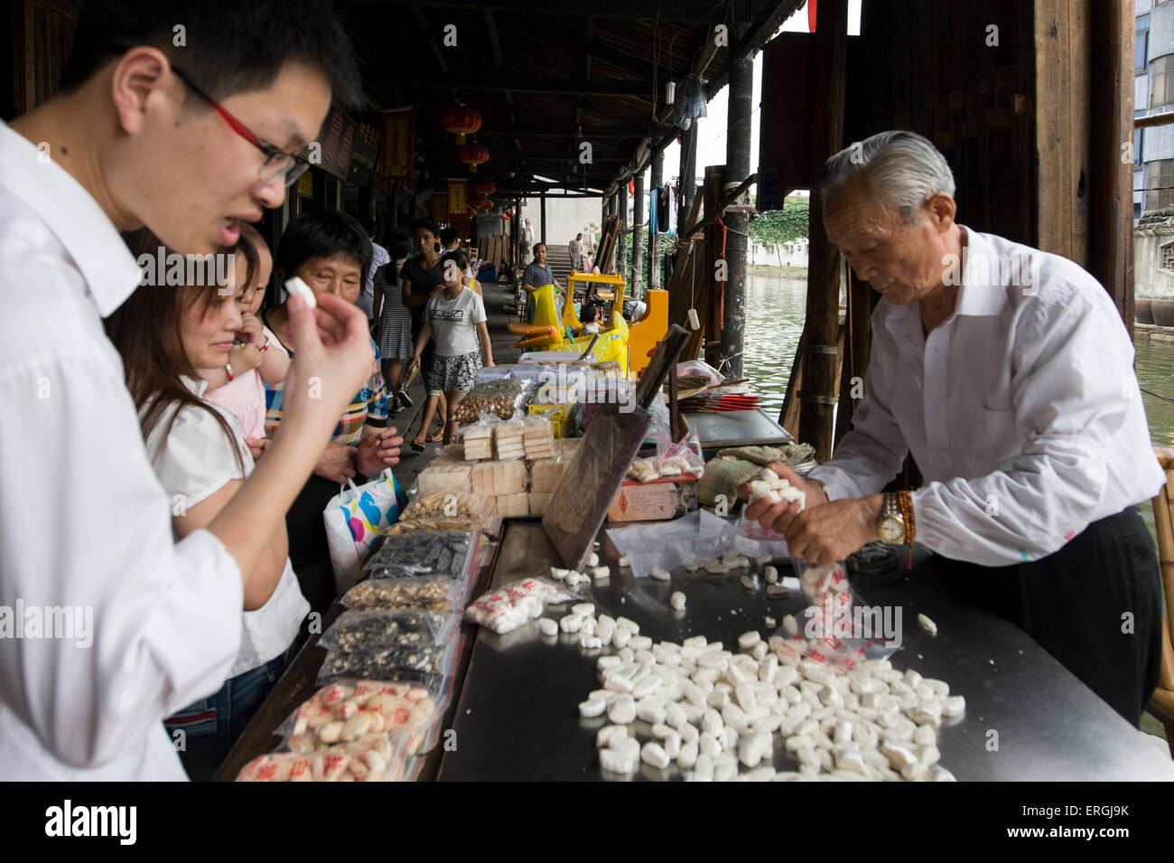 (150603) -- BEIJING, 3 juin 2015 (Xinhua) -- Chen Jinshui, héritier de la technique de l'extraction du sucre collante, regroupe jusqu'en sucre pour les clients de Anchang Canton de Shanghai, ville de la Chine de l'est la province du Zhejiang, le 2 juin 2015. Chen Jinshui, qui est de plus de 80 ans et a appris la technique de traction de sucre à partir de 13 ans, est toujours un moment fort qu'il met en valeur son tirant de sucre technique, un patrimoine immatériel de la culture, en Anchang. Sucre extrait de germes de blé sera chauffée dans un wok jusqu'à ce qu'il se transforme en sirop. Chen boules jusqu'à ce que le sirop et battre la goo retour vigoureusement et pour Banque D'Images