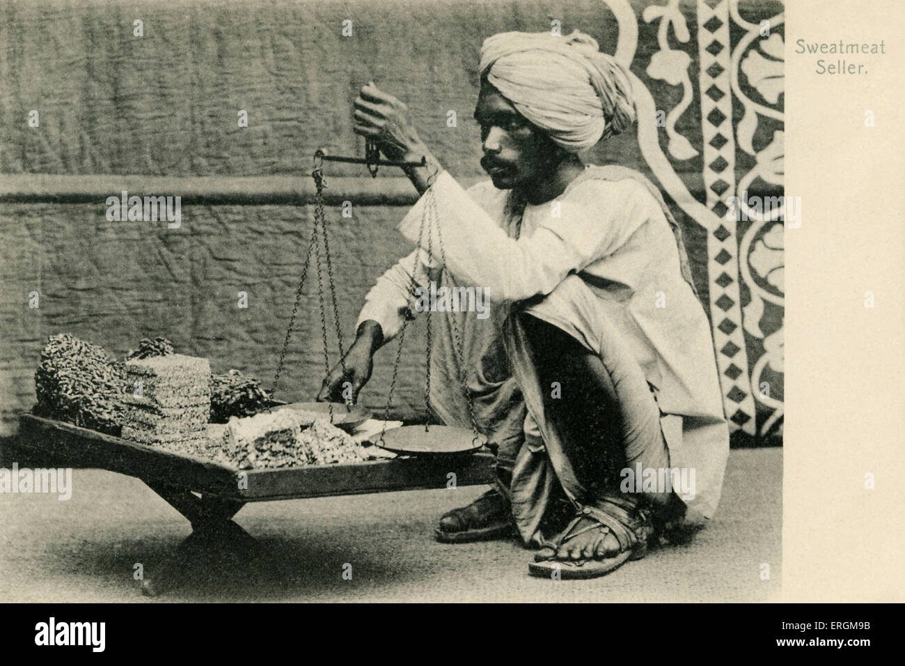 Vendeur sweetmeat indien. Photographie du début du xxe siècle. Le vendeur détient ses marchandises et échelles. Banque D'Images