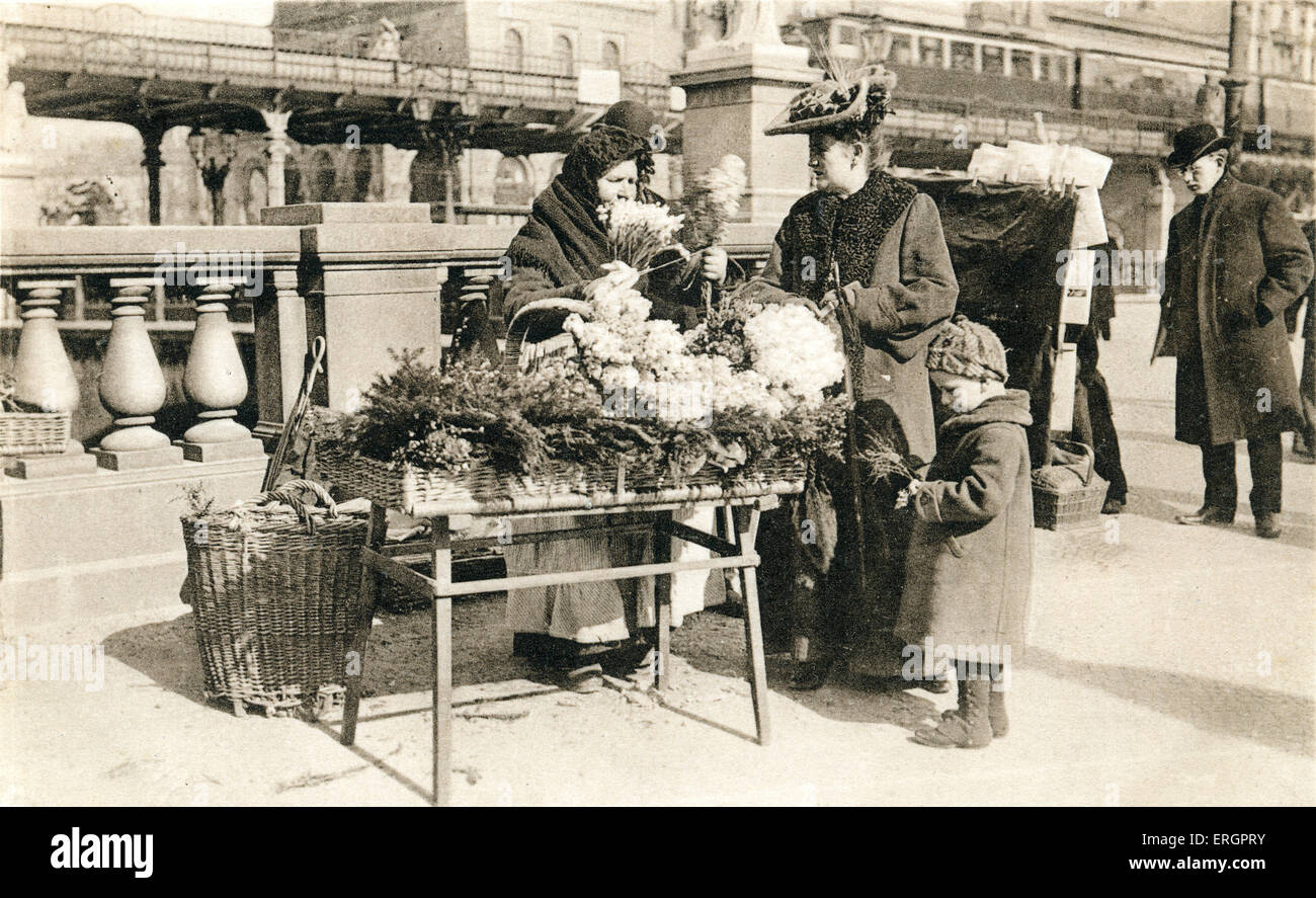 Marchande de fleurs à Berlin, au début du xxe siècle. Un étal vend porte-fleur pour une dame avec un enfant. Banque D'Images