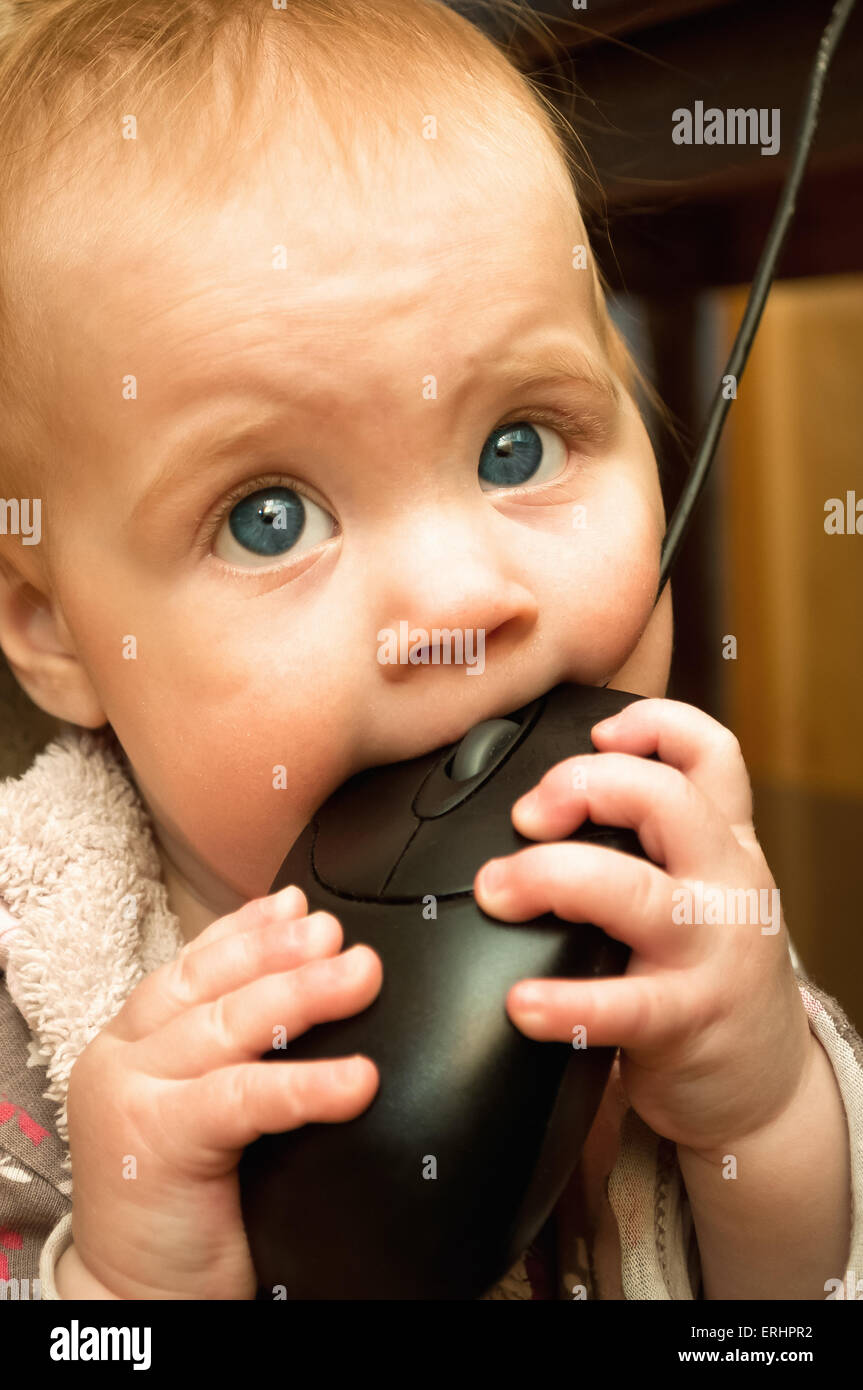 Petit bébé jouer avec la souris de l'ordinateur Banque D'Images