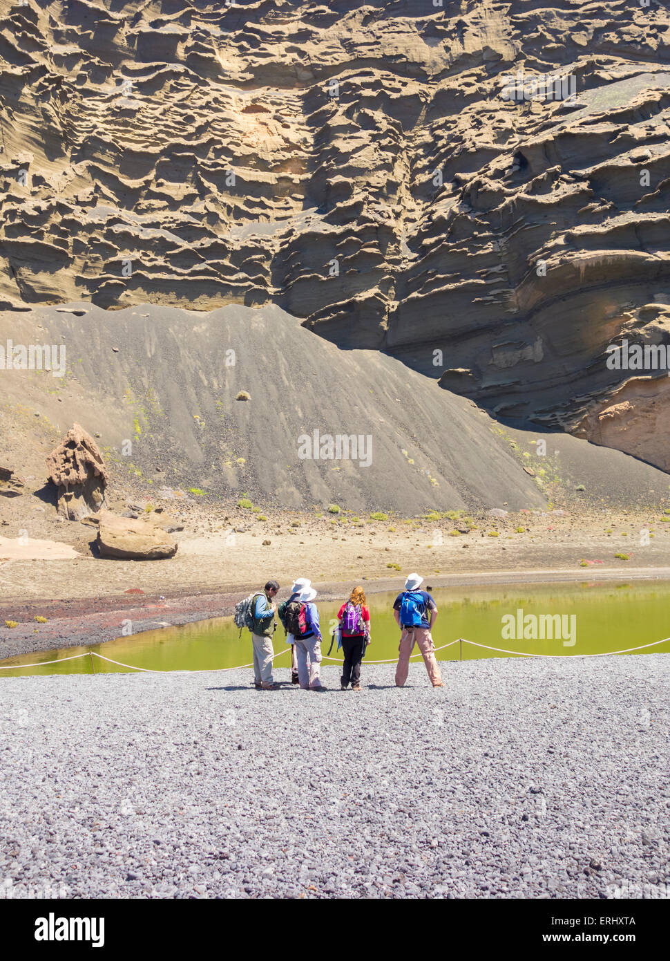 Groupe de marcheurs près de Green Lagoon, Charco de los Clicos, ci-dessous des falaises volcaniques à El Golfo sur Lanzarote, îles Canaries, Espagne Banque D'Images