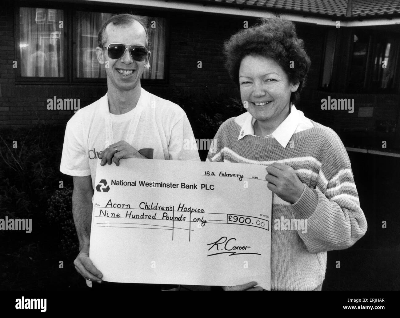Ray Carver remet un chèque de 900 à Sally Day, directrice Acorns Children's Hospice, Oak Tree Lane, de Selly Oak, Birmingham. 18 février 1990. L'argent recueilli dans le Vax Marathon. Banque D'Images
