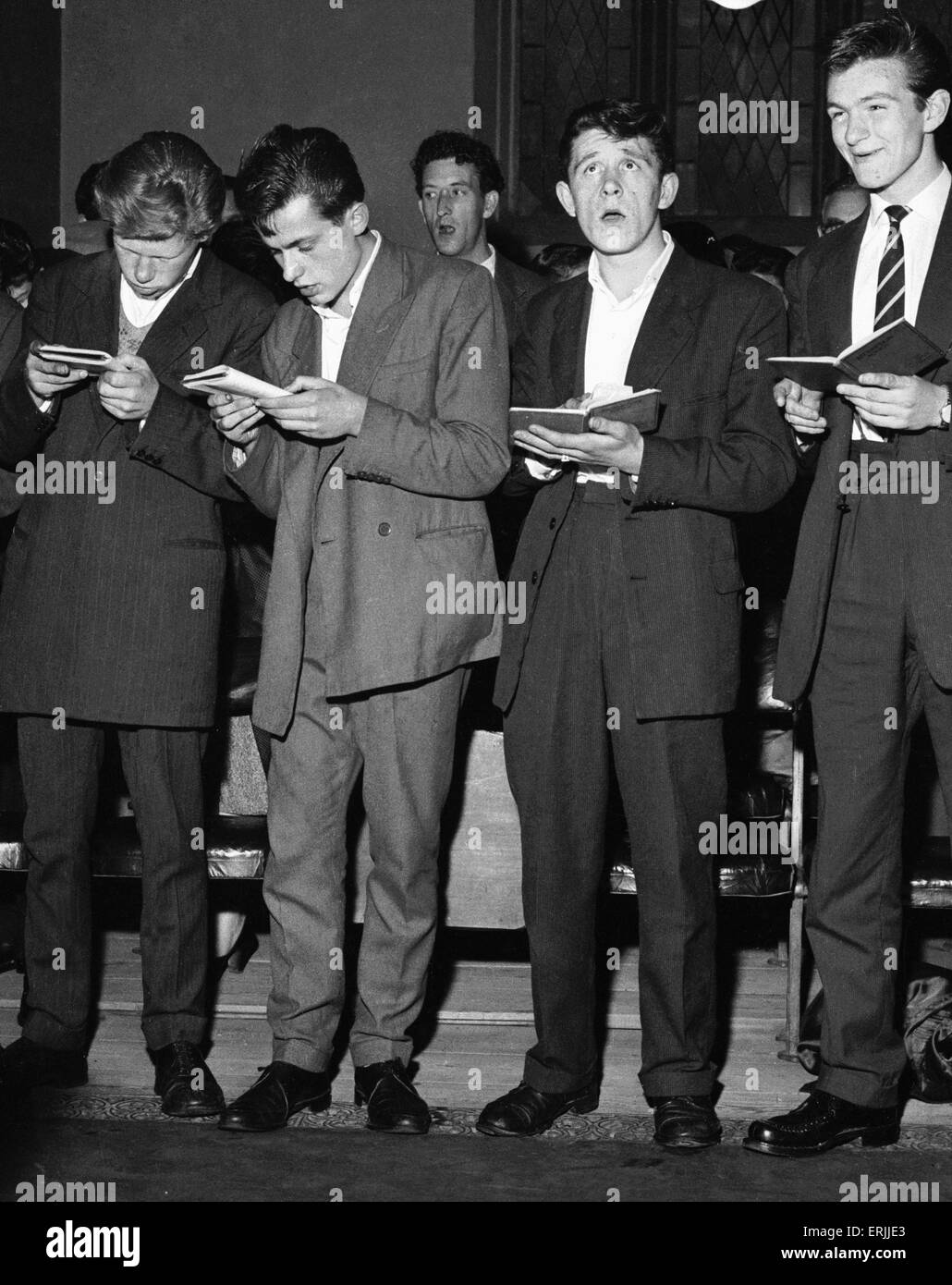 The Herald Angels... Teddy Boys qui ont assisté le service spécial pour les jeunes de 16 ans évangéliste américain Renee Martz au Kensington Temple Église pentecôtiste à Notting Hill Gate, vu ici chanter des hymnes. Churchworkers le tour des cafés et bars laitiers d'inviter les jeunes au service. 15 Juillet 1956 Banque D'Images