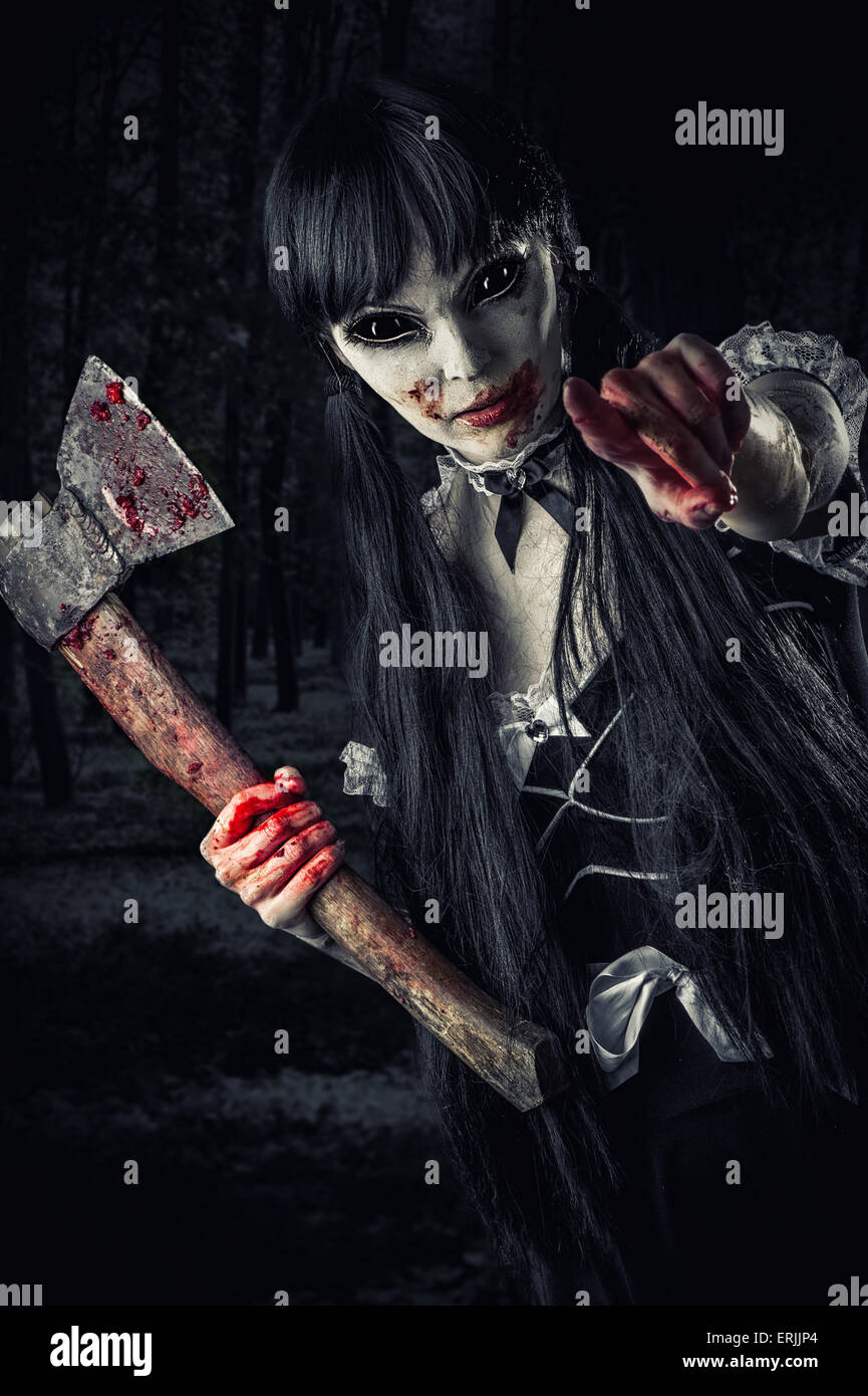 Zombie femme avec bloody axe s'étend à la main et tiré sur vous. Halloween concept. Le mal ghost en forêt de nuit Banque D'Images
