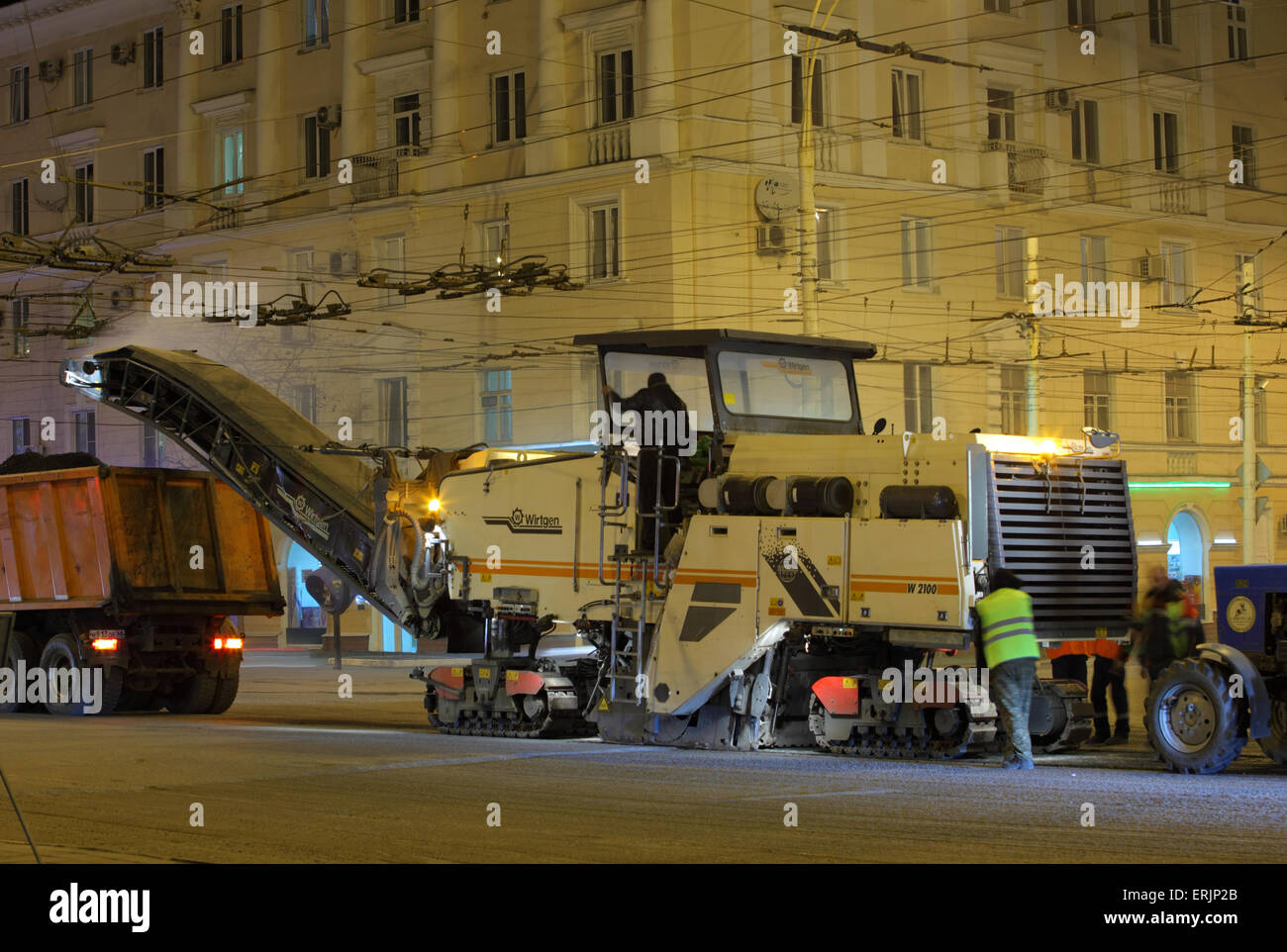 Les travaux routiers avec une route asphaltée fraiseuse dépose de l'ancienne chaussée à partir d'une nuit méplatdu côté rue Banque D'Images