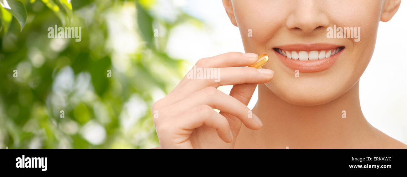 Beautiful woman holding capsule omega 3 vitamines Banque D'Images