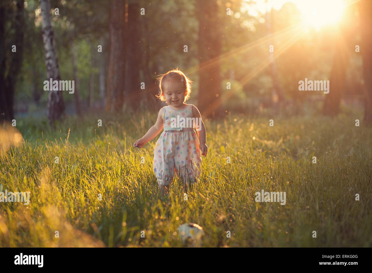 Bébé jouant dans des feux au coucher du soleil Photo Stock - Alamy