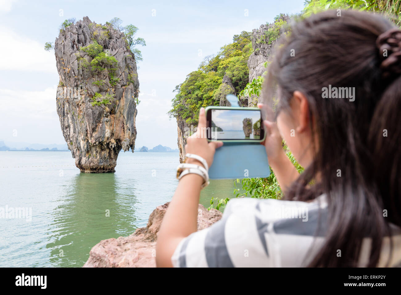 Female traveler il va prendre une photo un beau paysage naturel par téléphone cellulaire à Khao Tapu ou Île de James Bond dans Ao Phang Nga B Banque D'Images