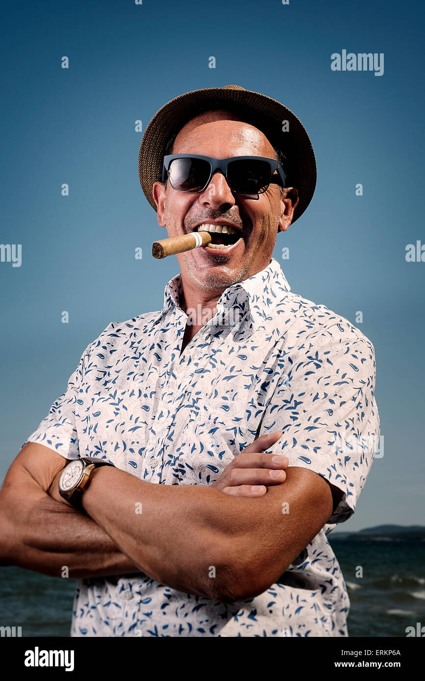 Homme avec un cigare sur la plage Photo Stock - Alamy