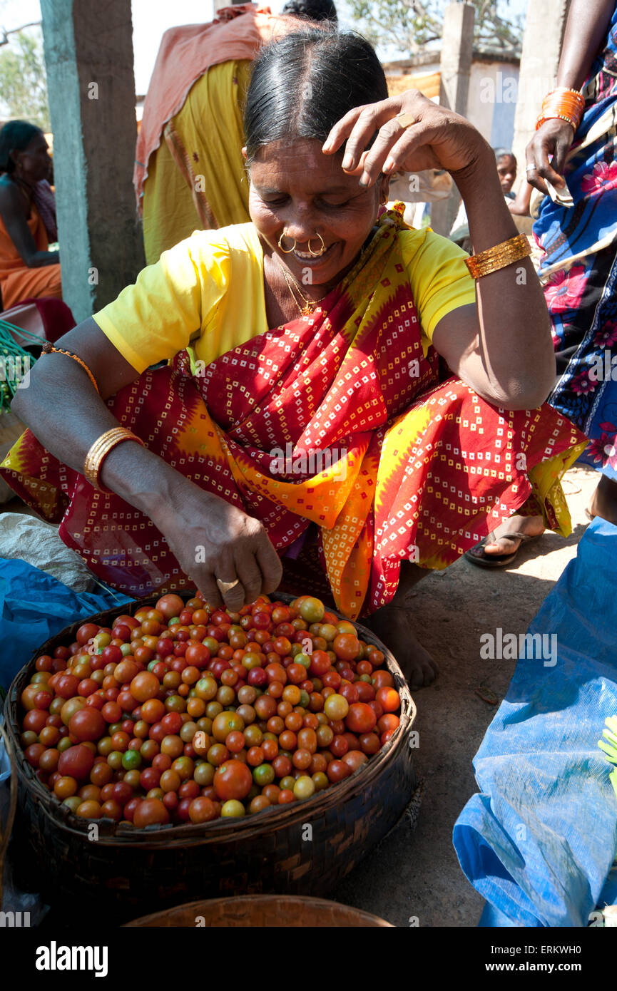 Mali tribeswoman noserings les tomates avec de l'or au Mali vente hebdomadaire marché tribal, Guneipada, district de Koraput, Orissa, Inde Banque D'Images