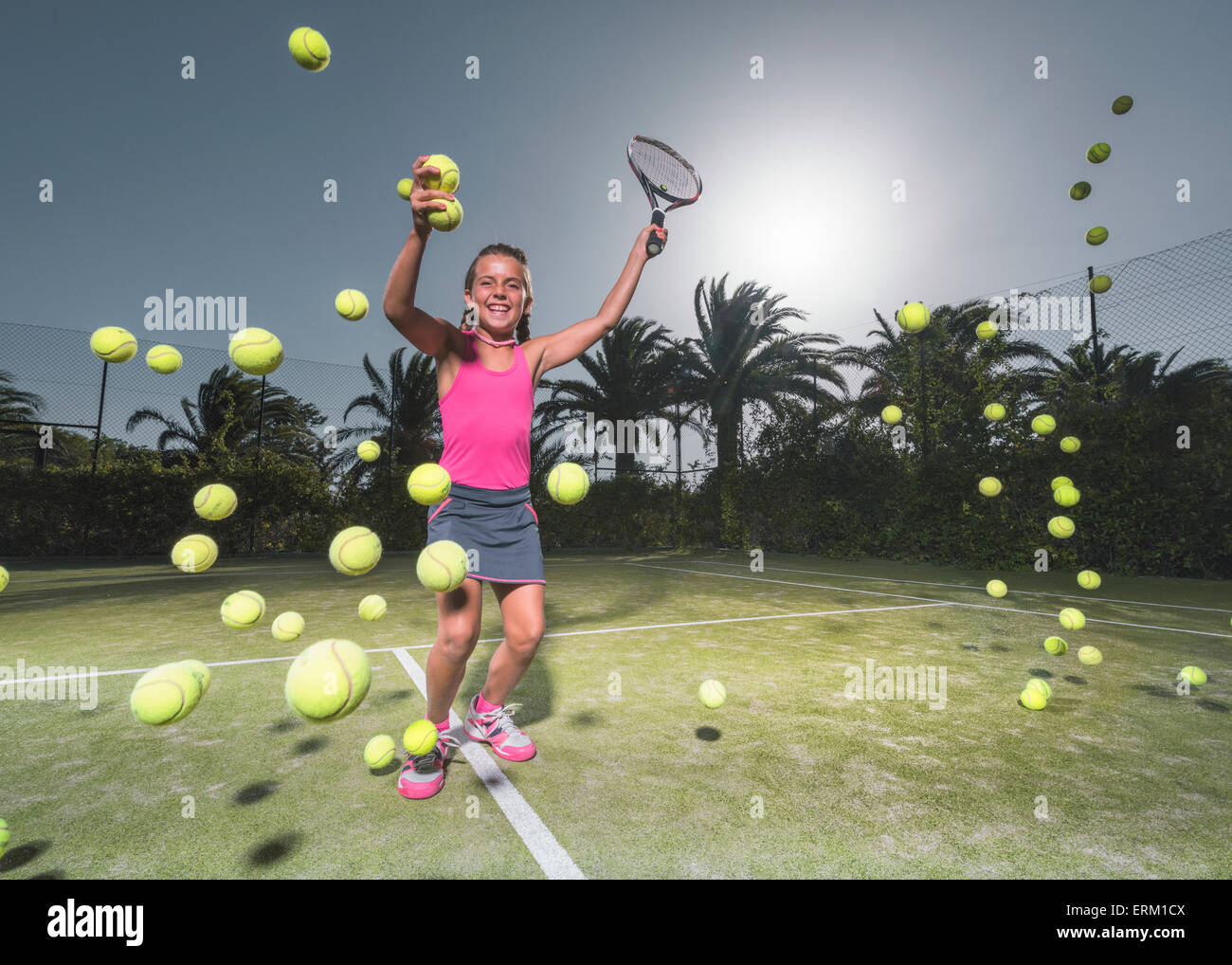 Une adolescente sur un court de tennis avec une raquette et de nombreuses balles de tennis ; Tarifa, Cadix, Andalousie, Espagne Banque D'Images