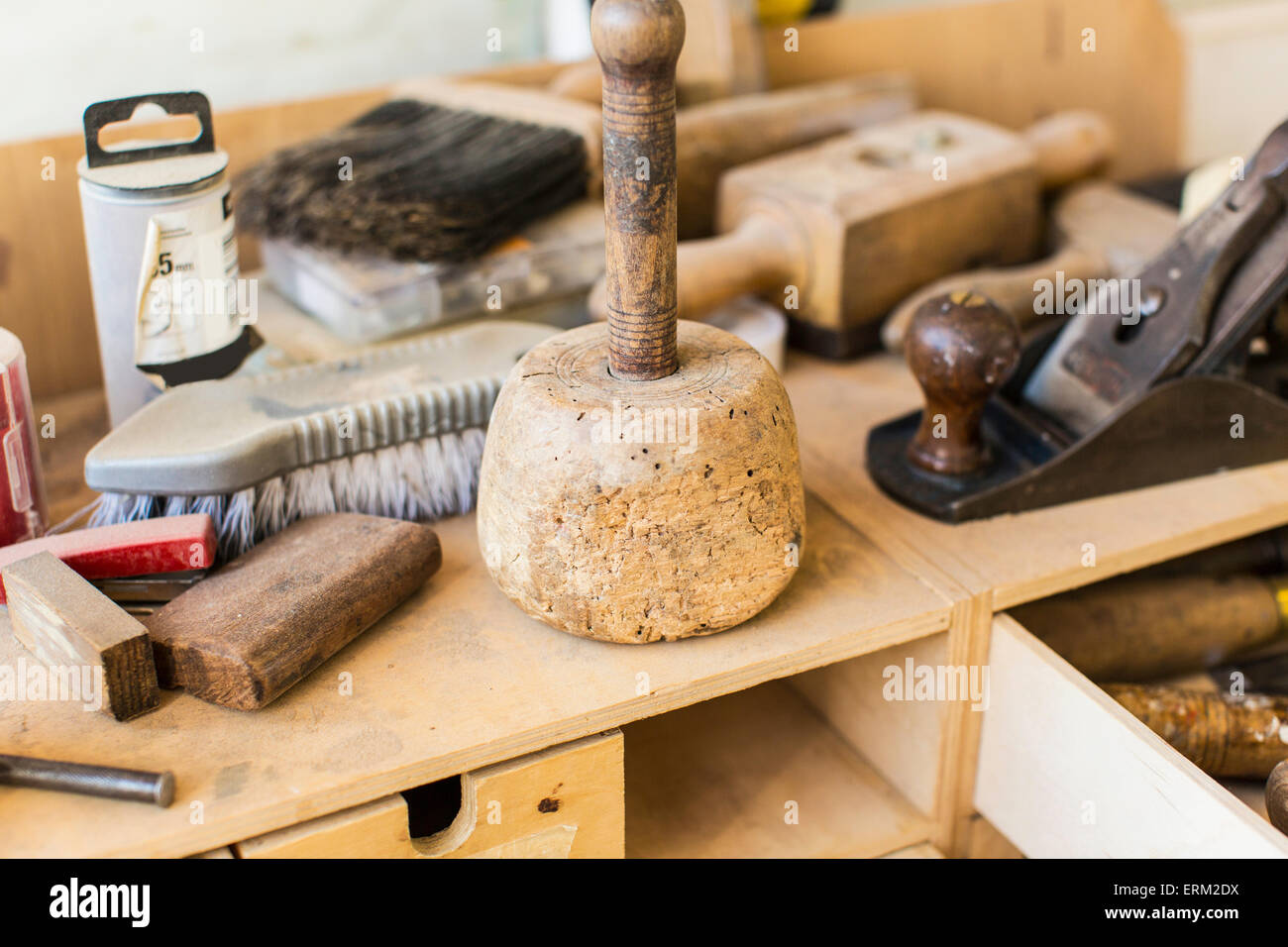 Atelier de restauration de meubles anciens. Un établi avec un woodplane, un grand maillet, balais et outils à main. Banque D'Images