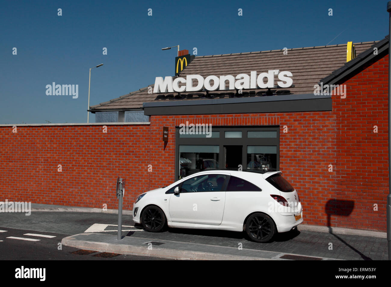 Le conducteur d'une voiture en attente d'être servis à la trappe du lecteur dans d'un restaurant McDonalds Banque D'Images