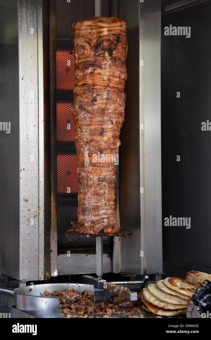 Les gyros de porc poulet de rôtisserie verticale sur la machine et le pain pita souvlaki grillé. Fast food traditionnel grec. Banque D'Images