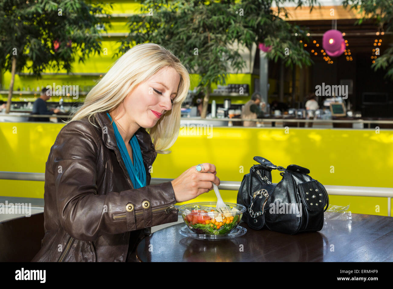 Jeune femme en train de déjeuner dans un café dans le centre commercial ; St Albert, Alberta, Canada Banque D'Images