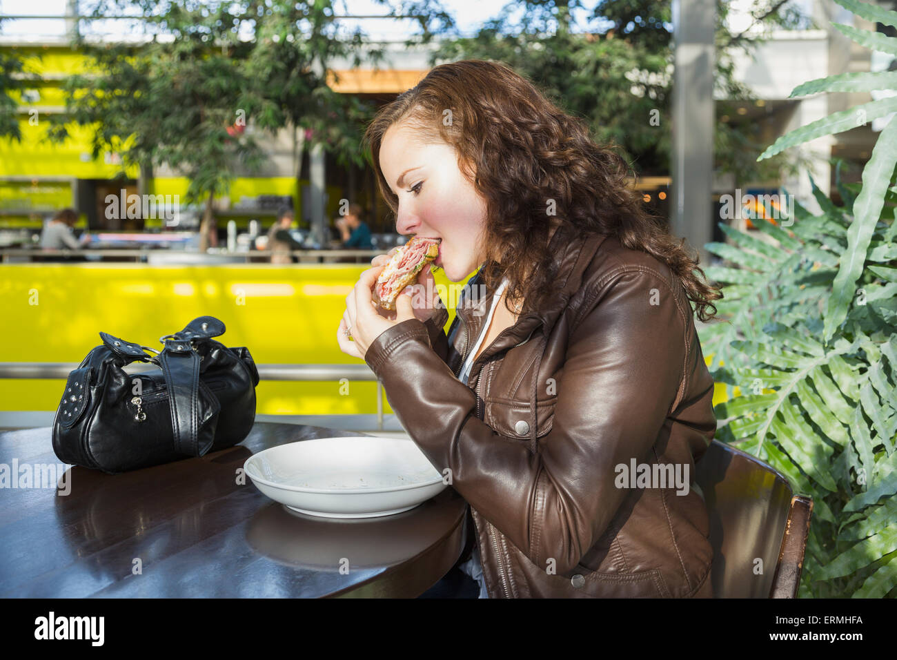 Jeune femme en train de déjeuner dans un café dans le centre commercial ; St Albert, Alberta, Canada Banque D'Images